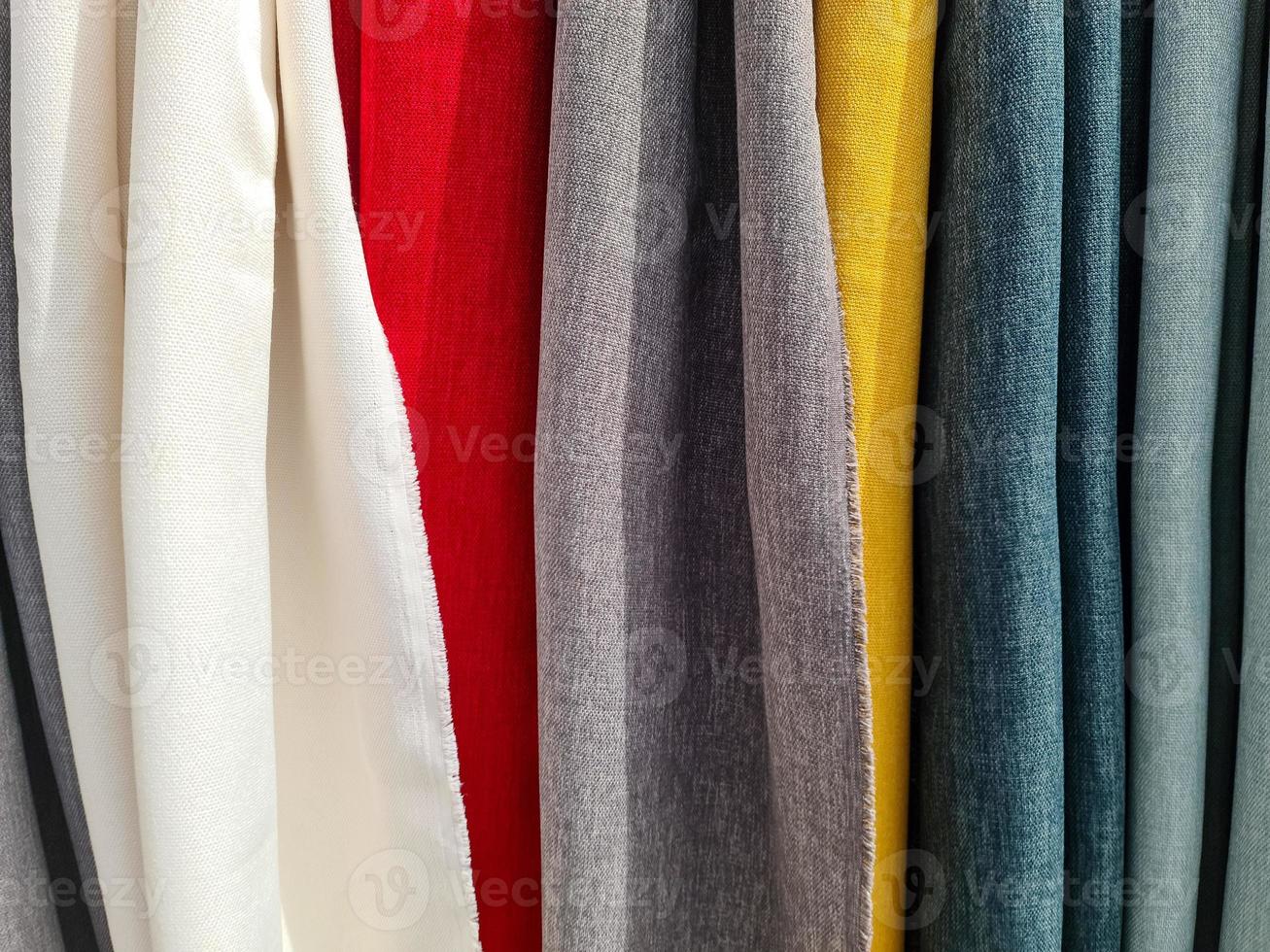 Detailed close up view on samples of cloth and fabrics in different colors found at a fabrics market photo