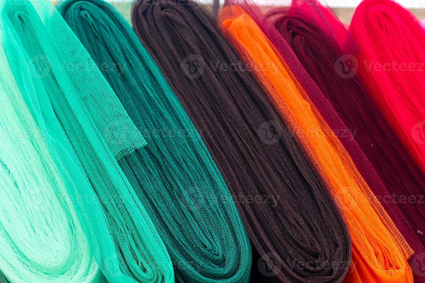 Detailed close up view on samples of cloth and fabrics in different colors found at a fabrics market photo