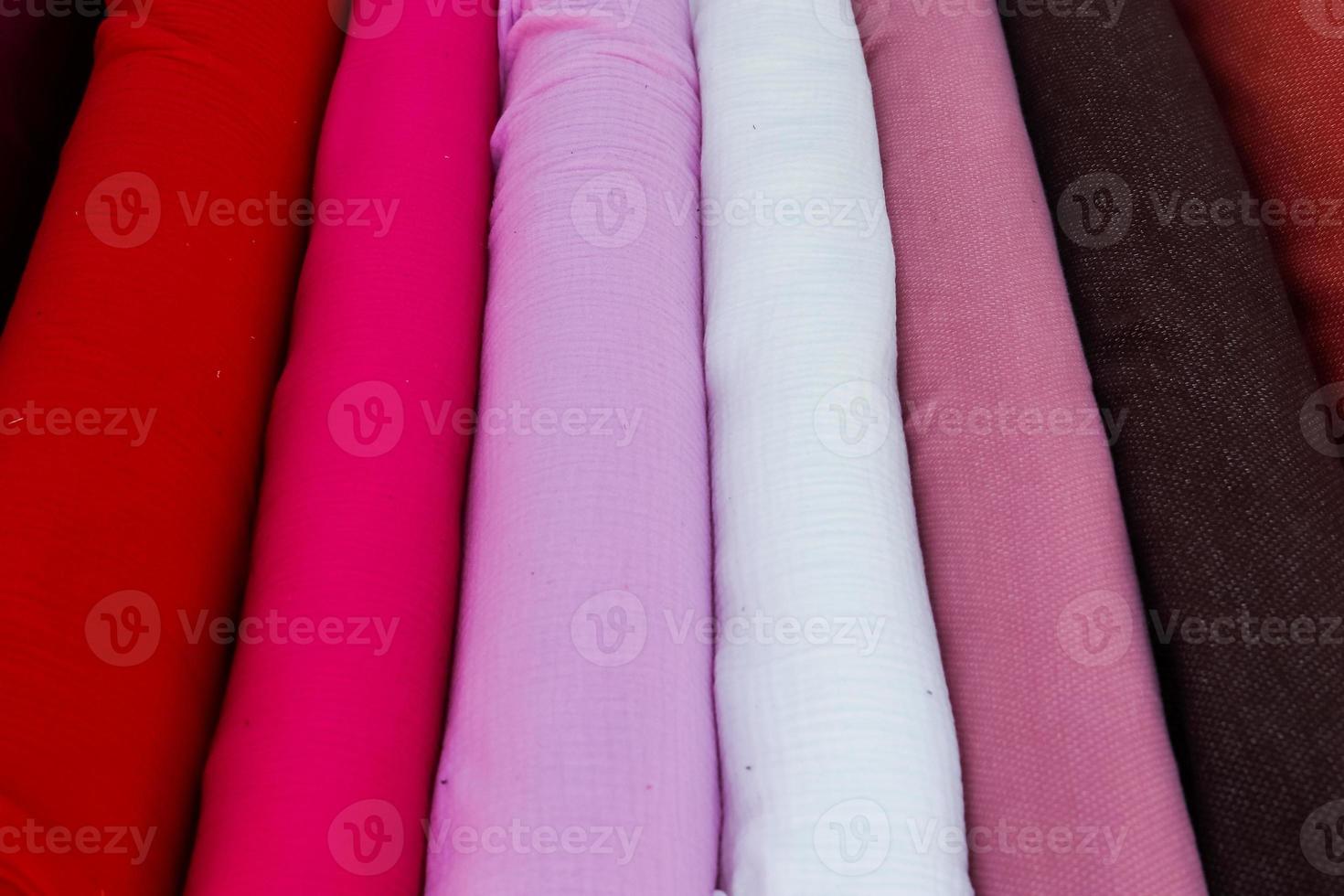 Detailed close up view on samples of cloth and fabrics in different colors found at a fabrics market photo