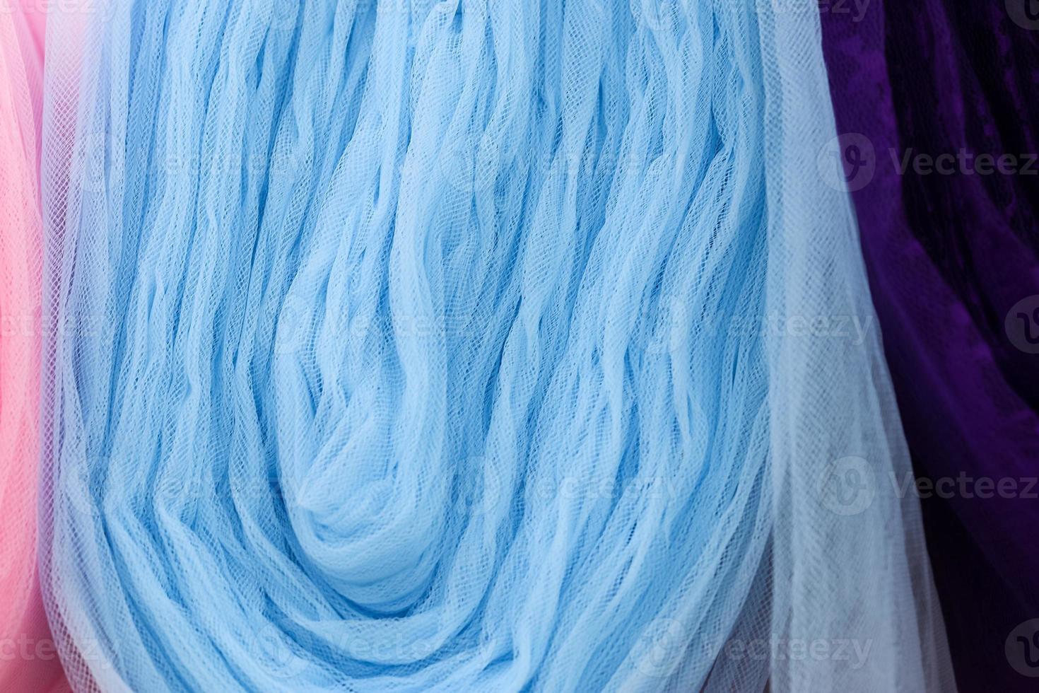 Detailed close up view on samples of cloth and fabrics in different colors found at a fabrics market photo