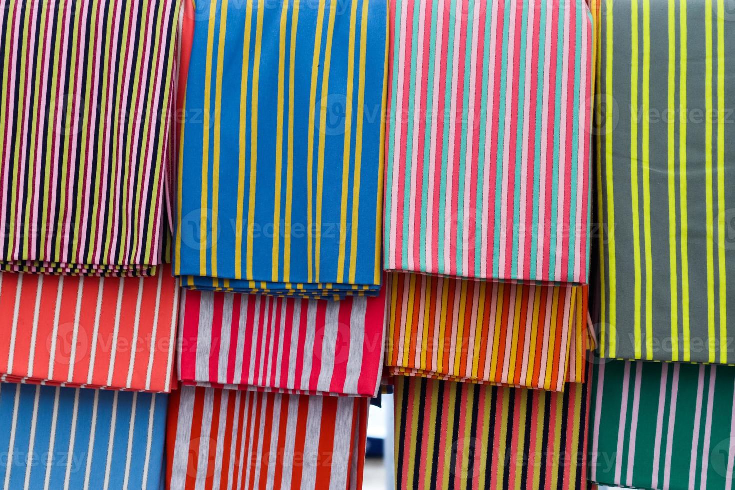 Detailed close up view on samples of cloth and fabrics in different colors found at a fabrics market photo