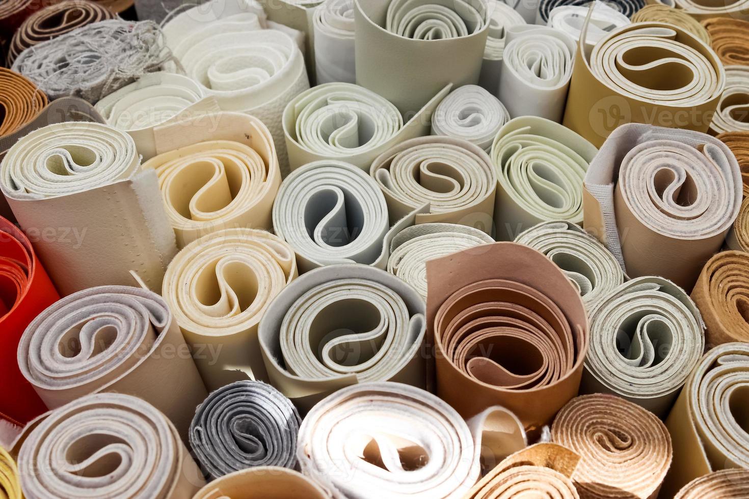Close up view on rolled samples of cloth and fabrics in different colors found at a fabrics market.. photo