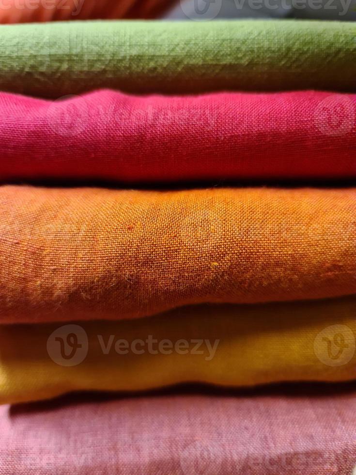Detailed close up view on samples of cloth and fabrics in different colors found at a fabrics market photo