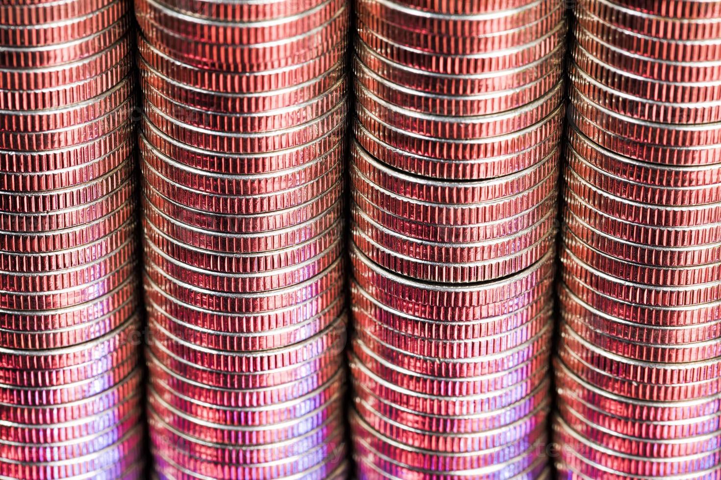 many round metal coins of silver color illuminated in red photo