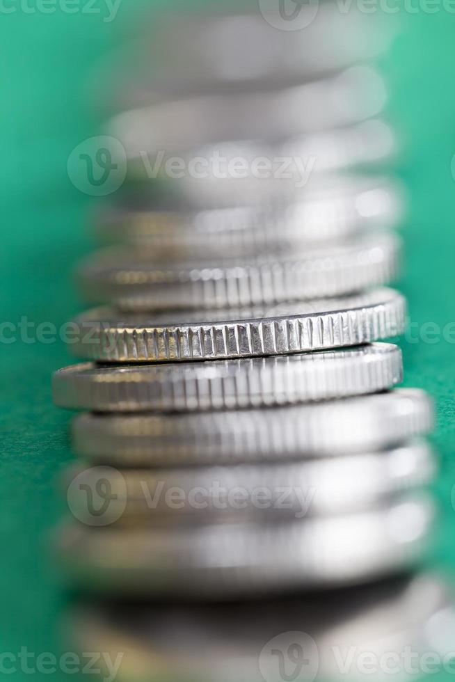 muchas monedas redondas de metal de color plateado iluminadas en verde foto