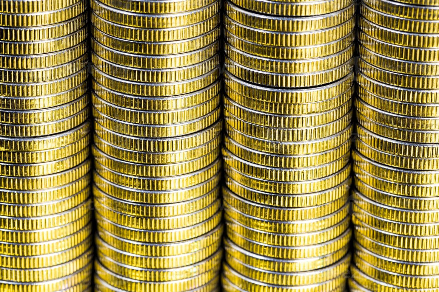 many round metal coins of silver color illuminated in yellow photo