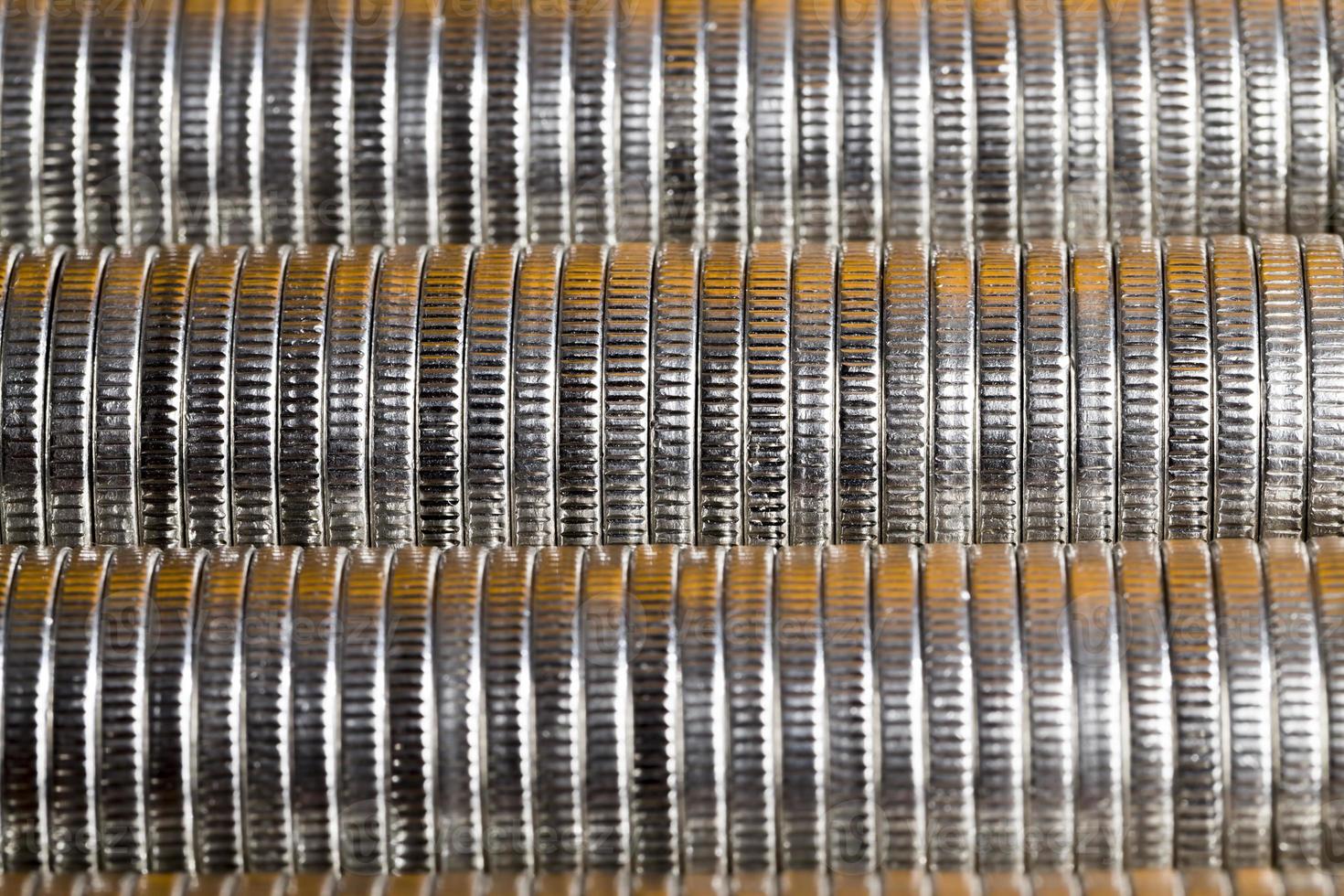 many round metal coins of silver color illuminated with Golden color photo