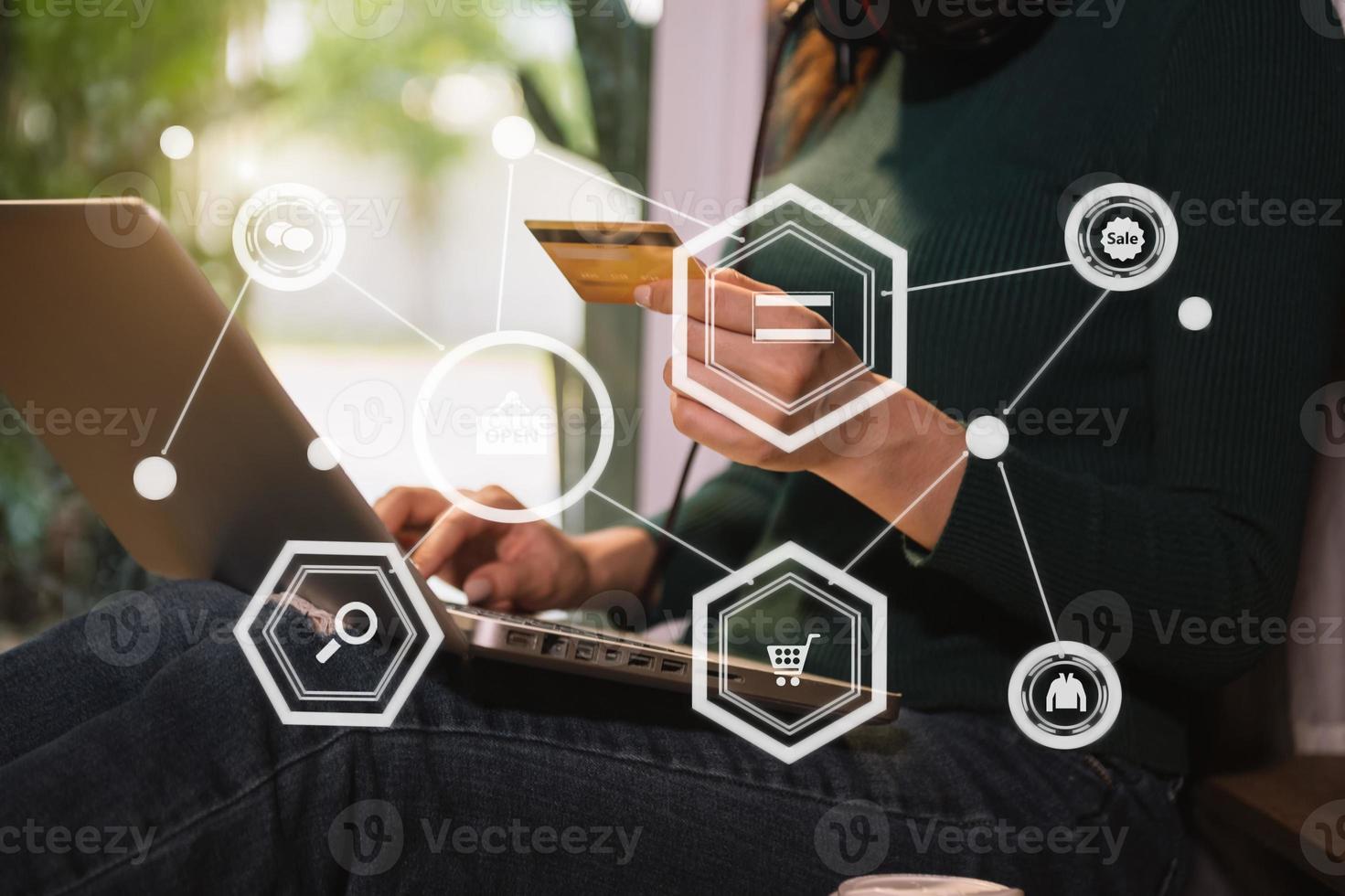 Close up of Hand using credit card and smartphone, laptop computer on wooden desk with VR icon chart graph diagram photo
