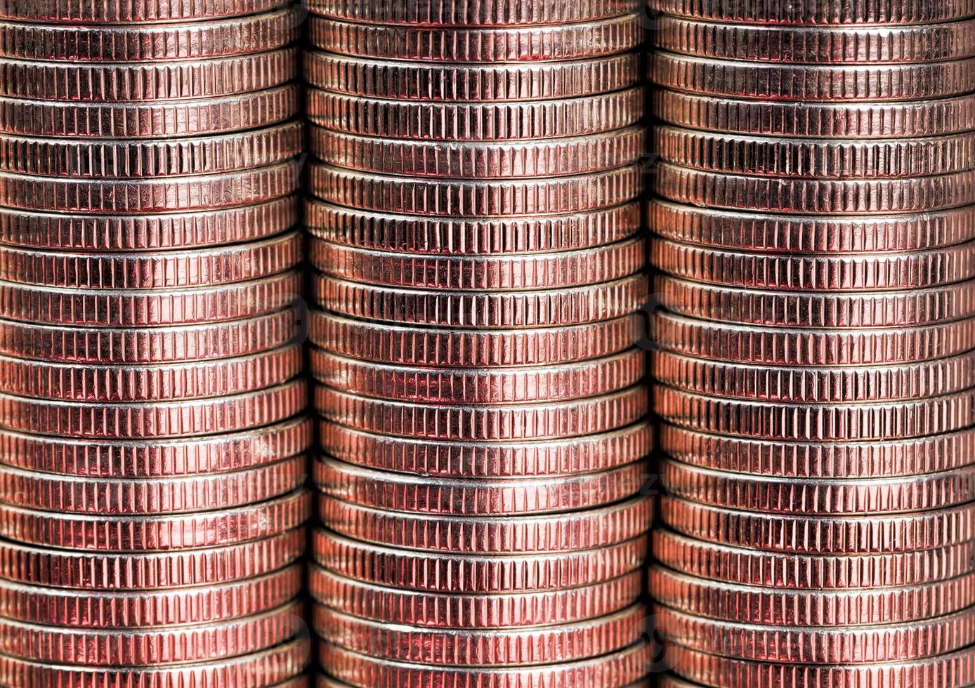 many round metal coins of silver color illuminated in red photo
