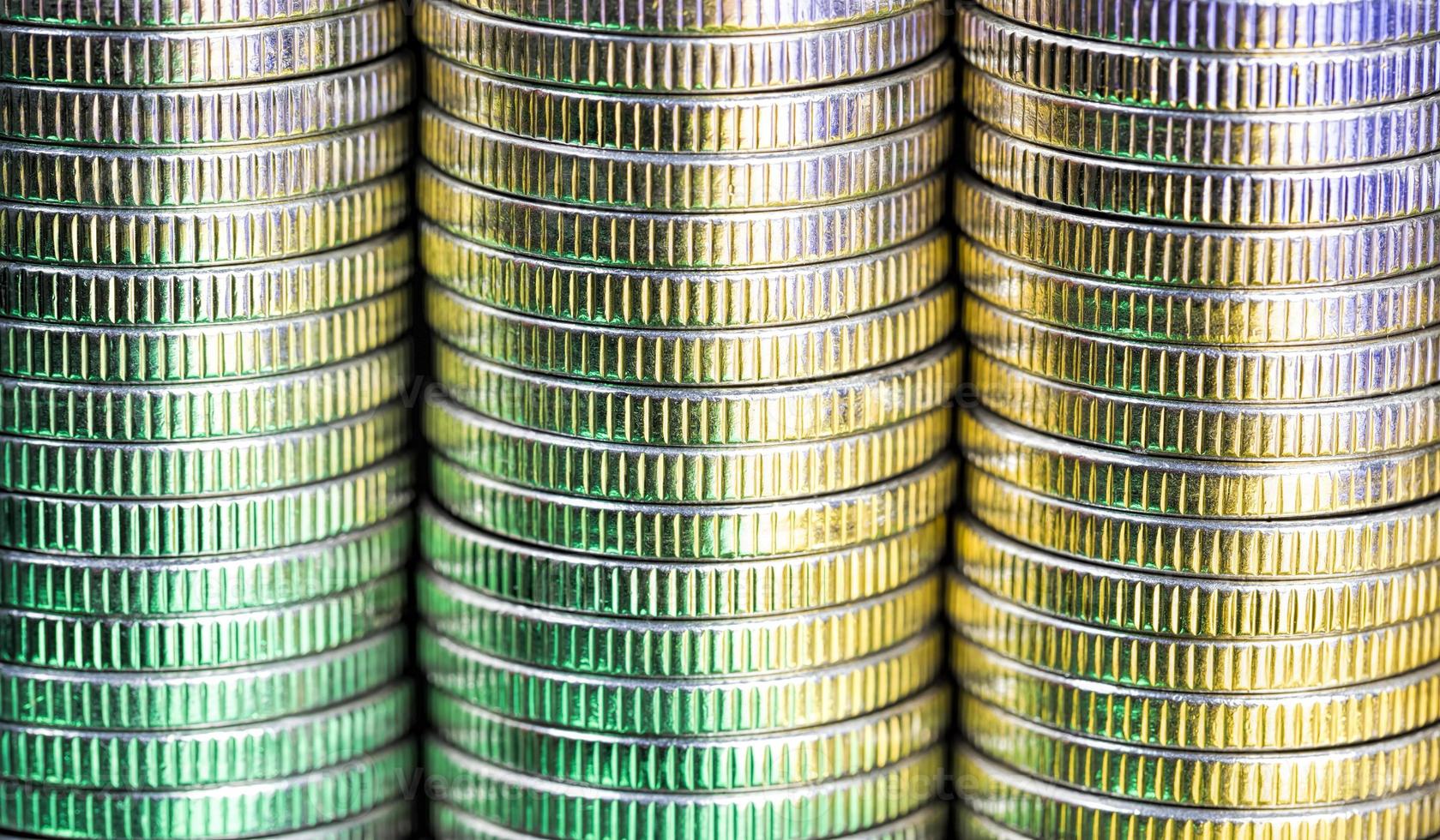 many round metal coins of silver color illuminated in green photo