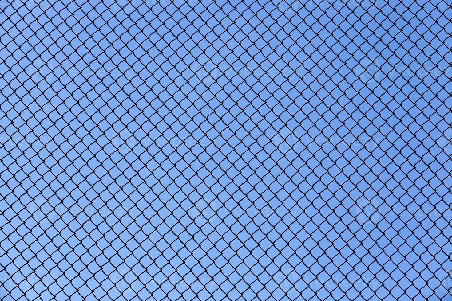 antigua valla de alambre hecha de alambre fino contra el cielo azul foto