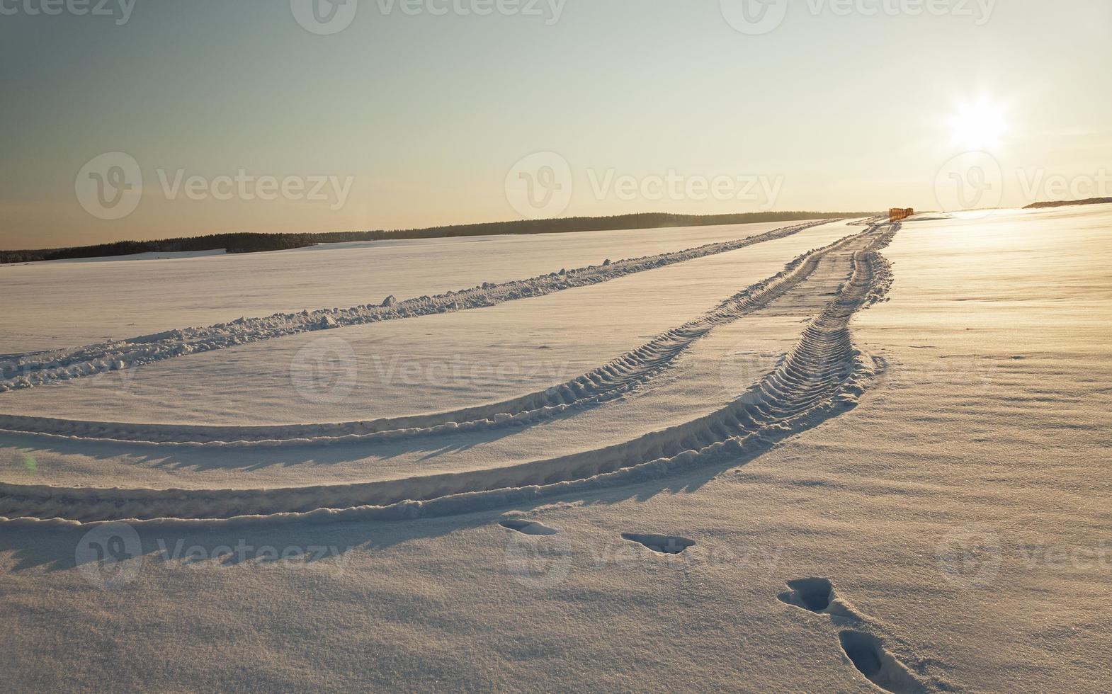 the road to a field - the rural road in an agricultural field in a winter season photo