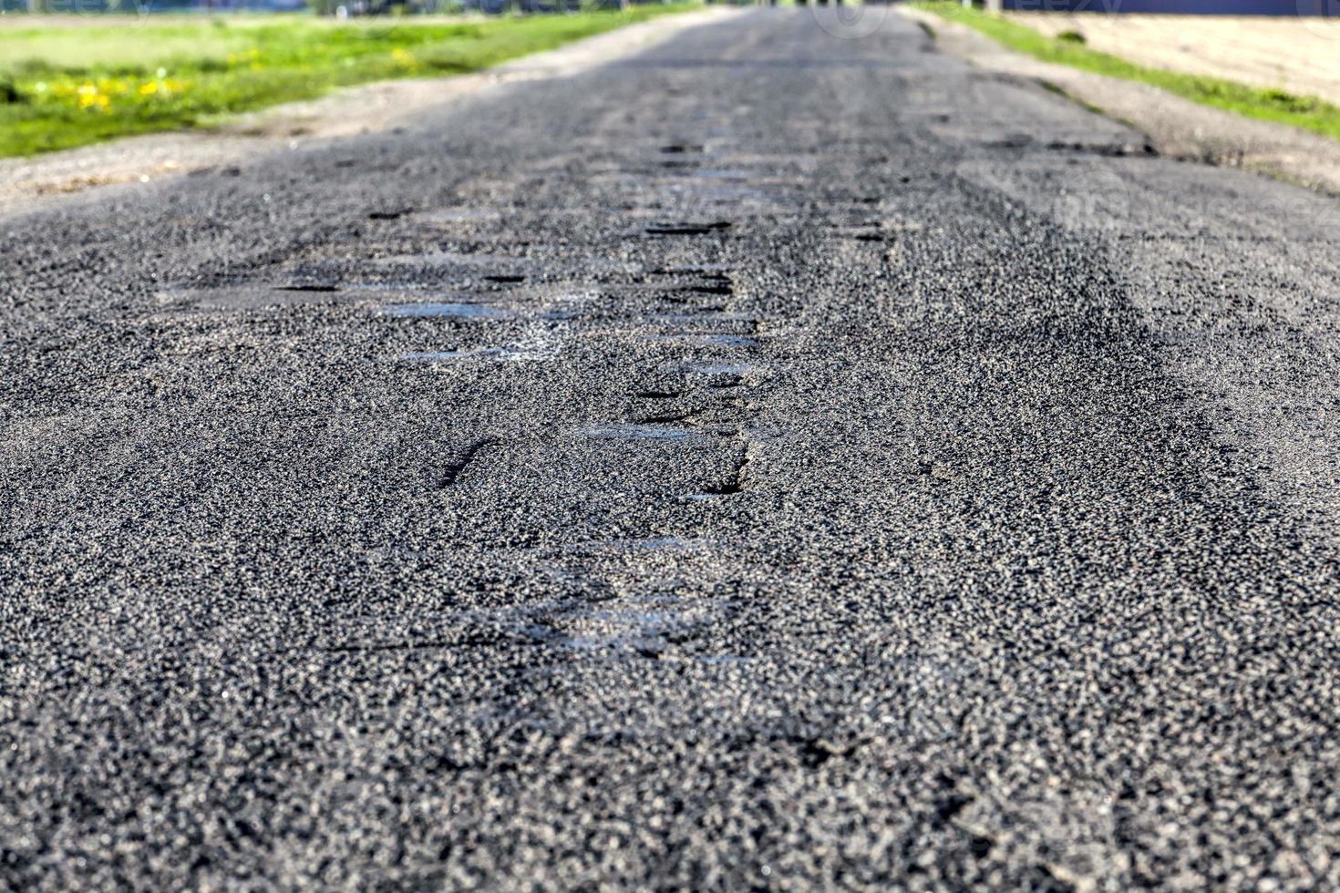 asphalt road that needs repaired photo