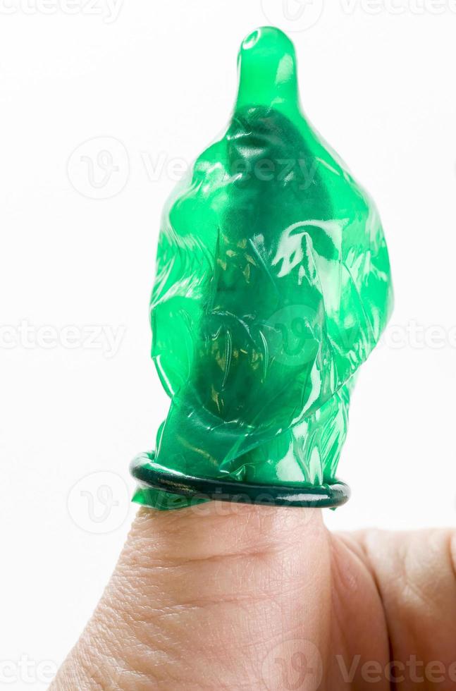 green latex condom on the finger, photo