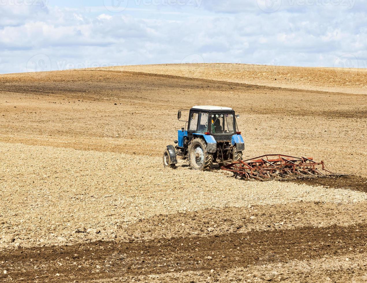 an old tractor plows the soil photo