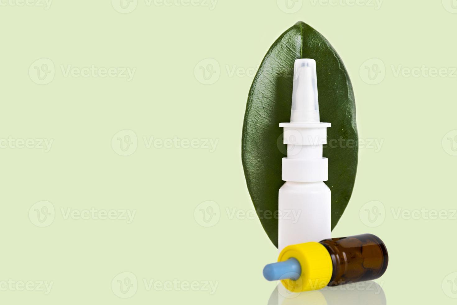 Medicinal nasal spray, green leaf on a white background. Copy space. photo