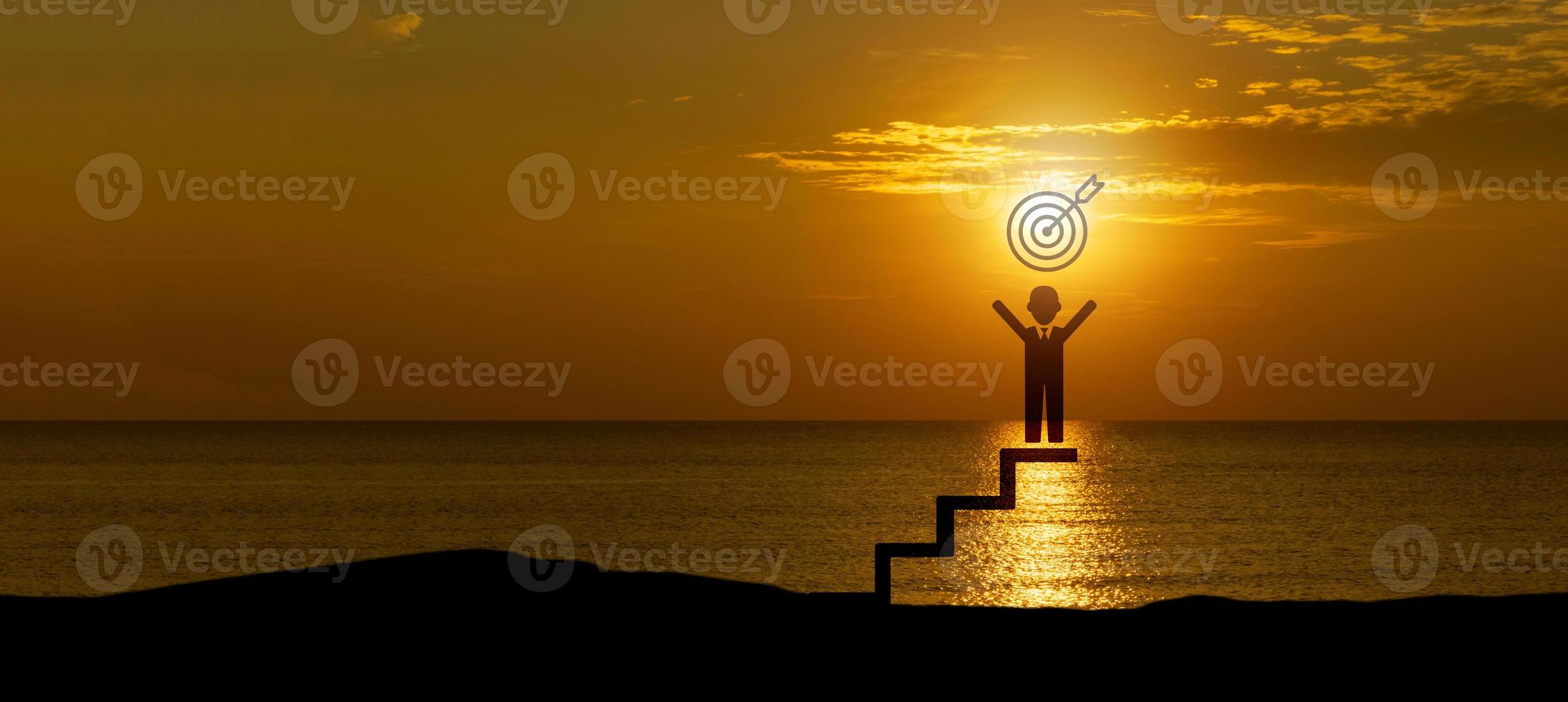 Silhouette of man icon holding a target board on top of  ladder, concept of aim and objective achievement. photo
