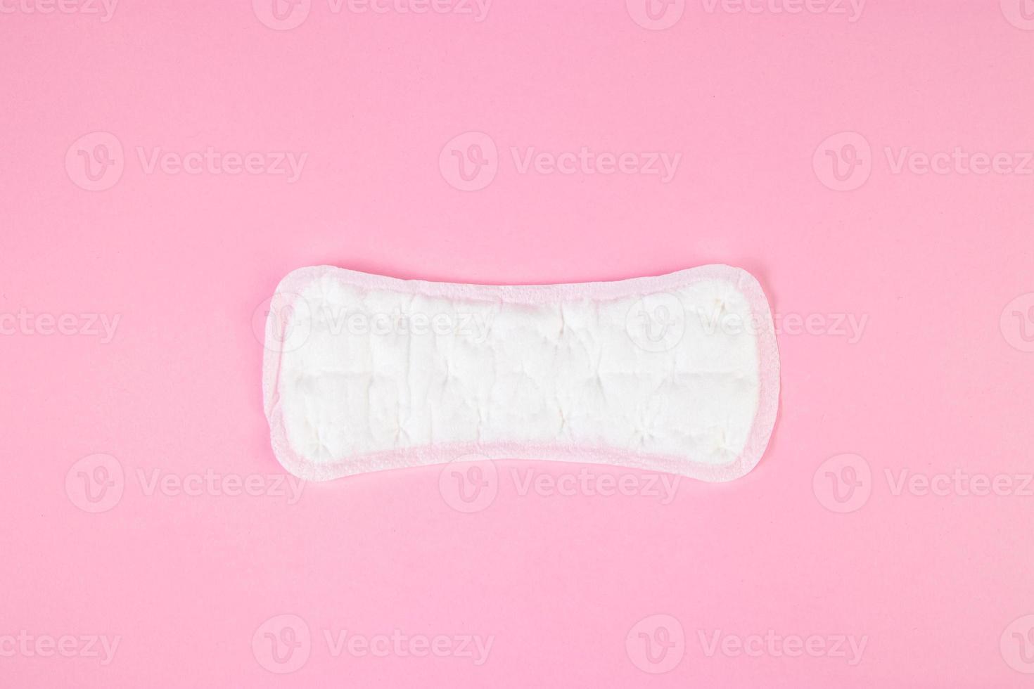 Sanitary pad on pink background. Daily feminine hygiene product. Menstruation concept. photo