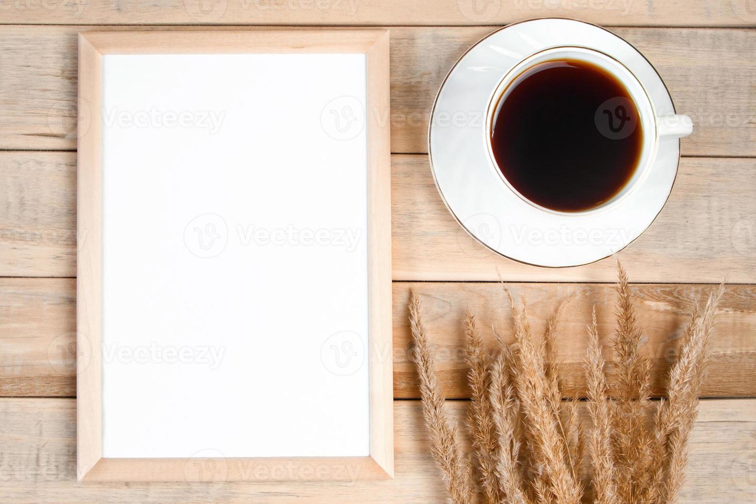 Autumn flat lay. Cup of hot espresso coffee and fallen yellow leaves on wooden background. Empty frame mock up for text. Morning concept. photo