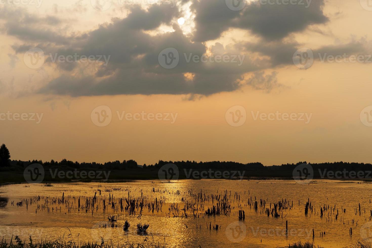 lake during sunset with yellow orange sky photo