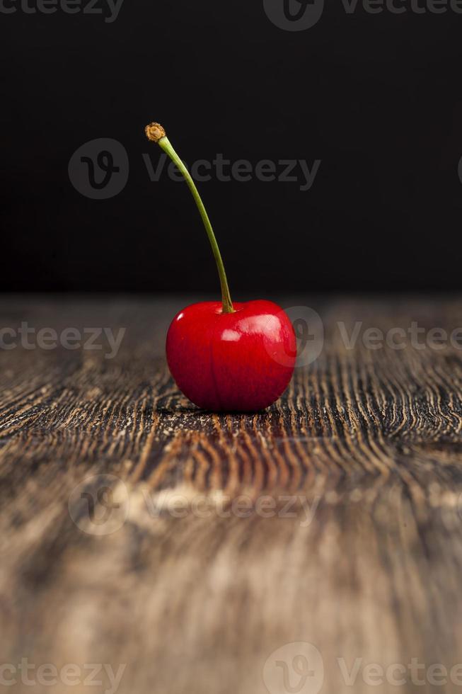 red ripe sweet cherries on a wooden table photo