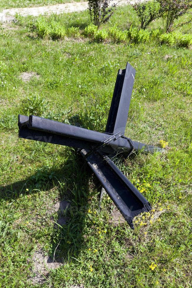 anti tank metal fortifications and hedgehogs on green grass photo