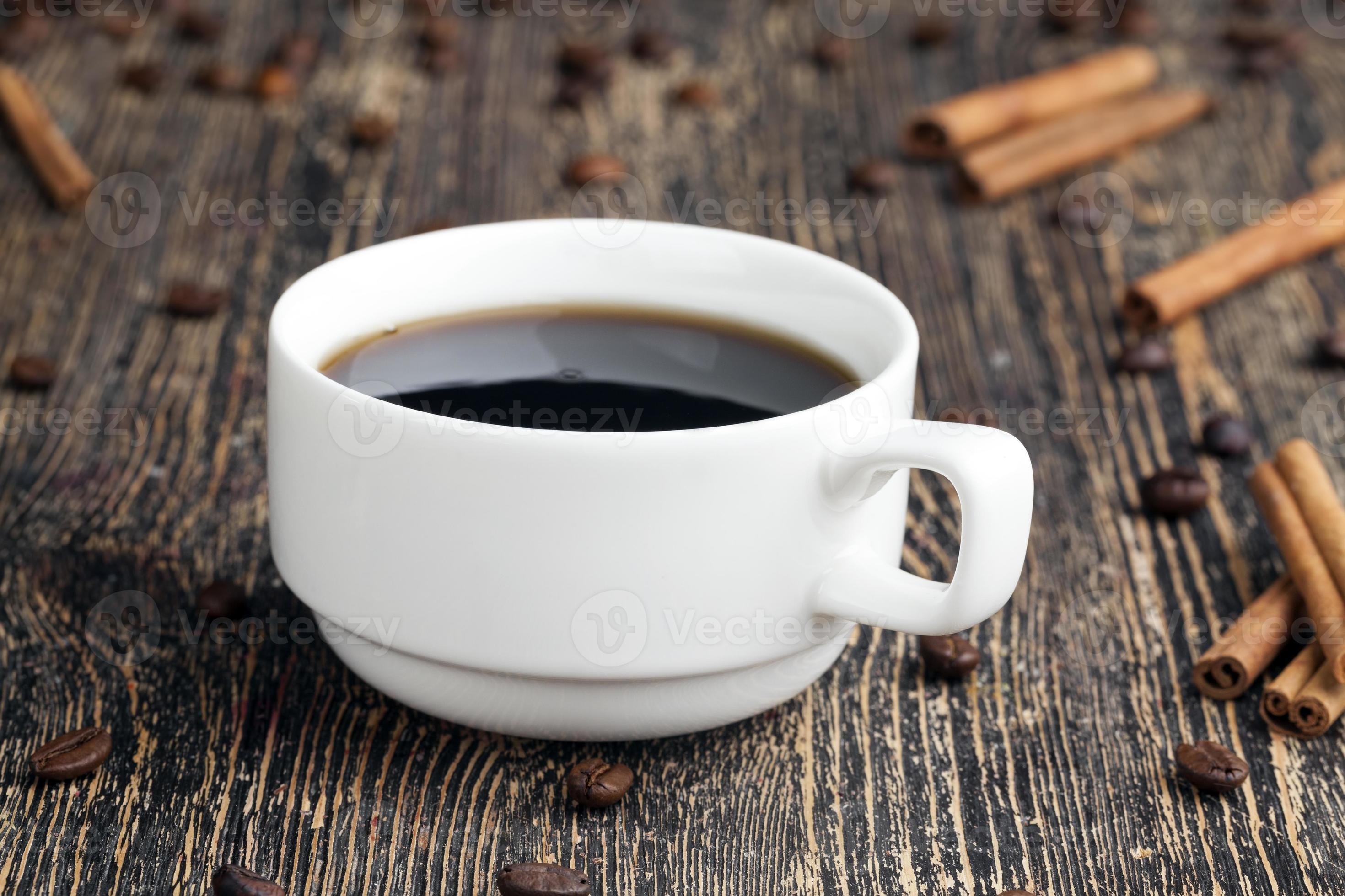 a white mug with a black drink and coffee beans 9439332 Stock Photo at