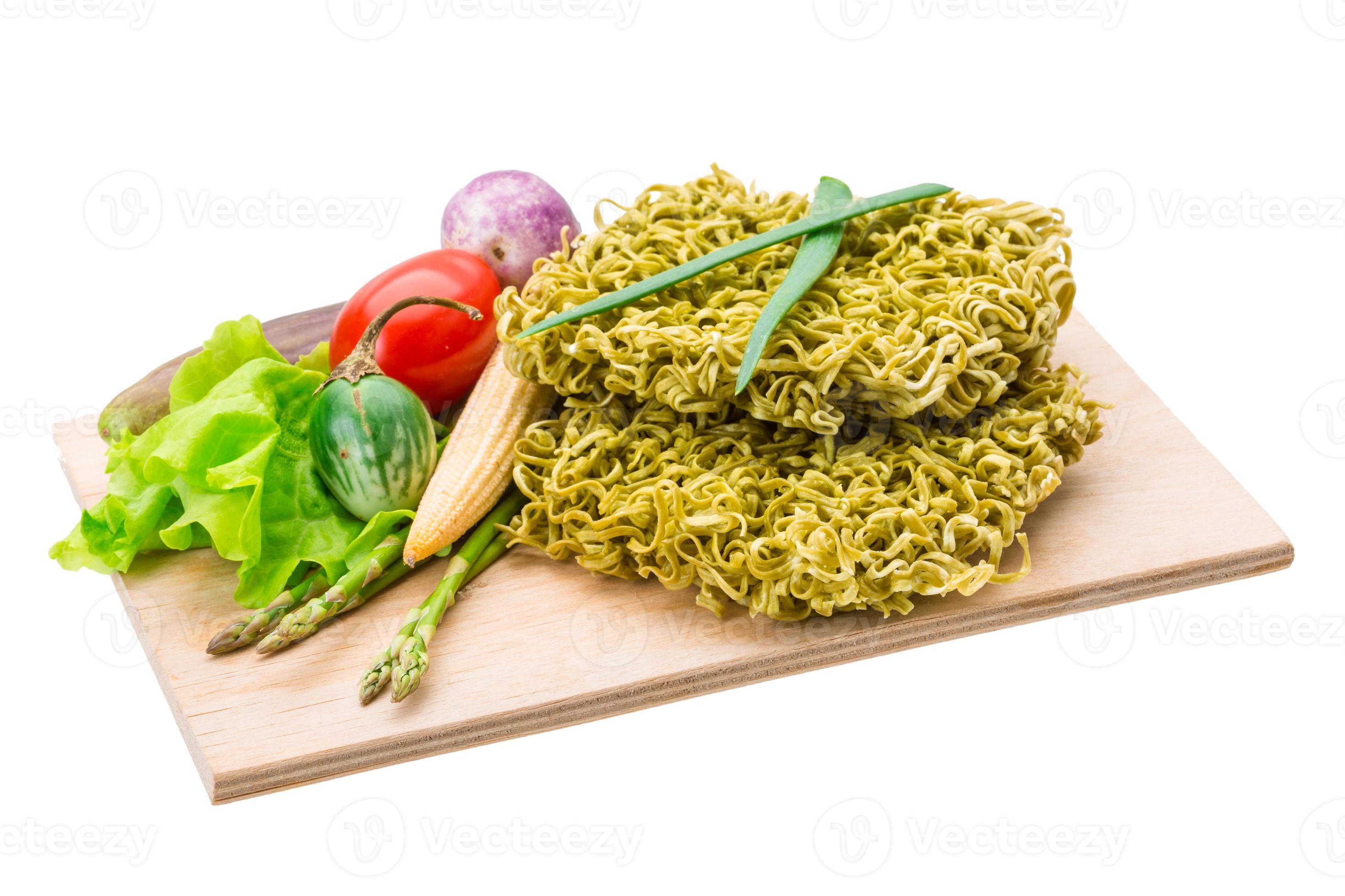 Green raw noodles on wooden plate and white background 9440122 Stock