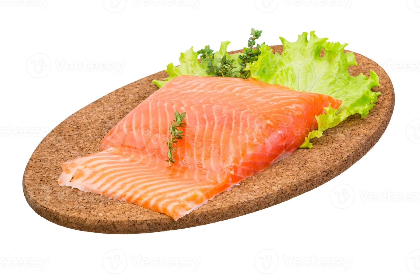 filete de salmón en placa de madera y fondo blanco. foto