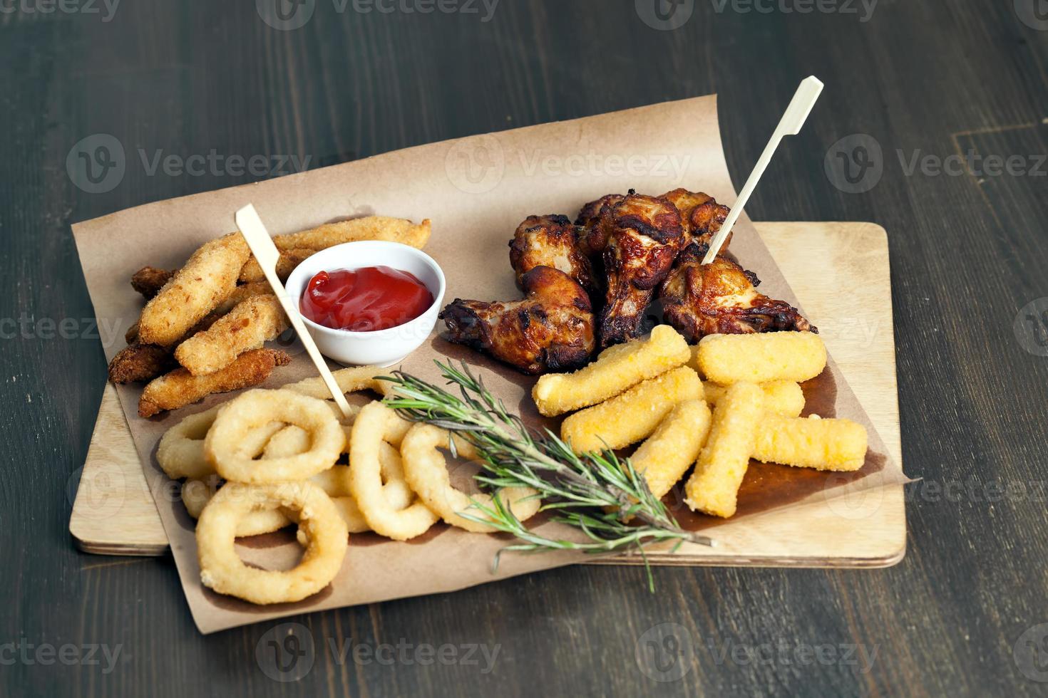 a set of dishes consisting of baked chicken wings , sets in a cafe photo