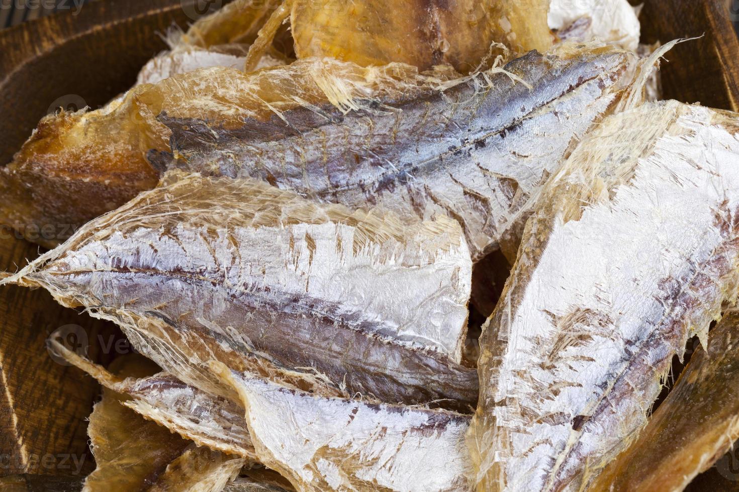 dried and butchered small fish on a wooden table photo