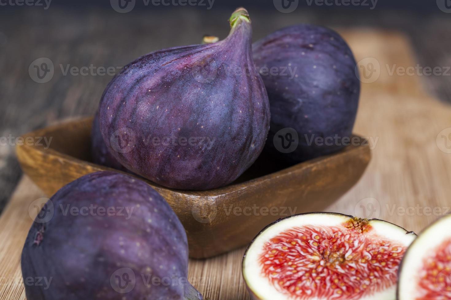 ripe purple figs on a wooden table photo