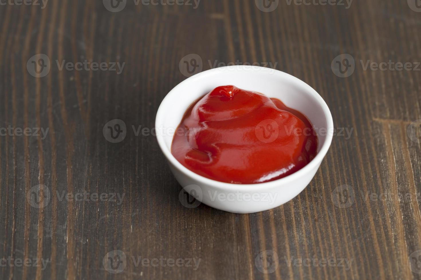 ketchup de tomate rojo vertido en un plato rojo foto