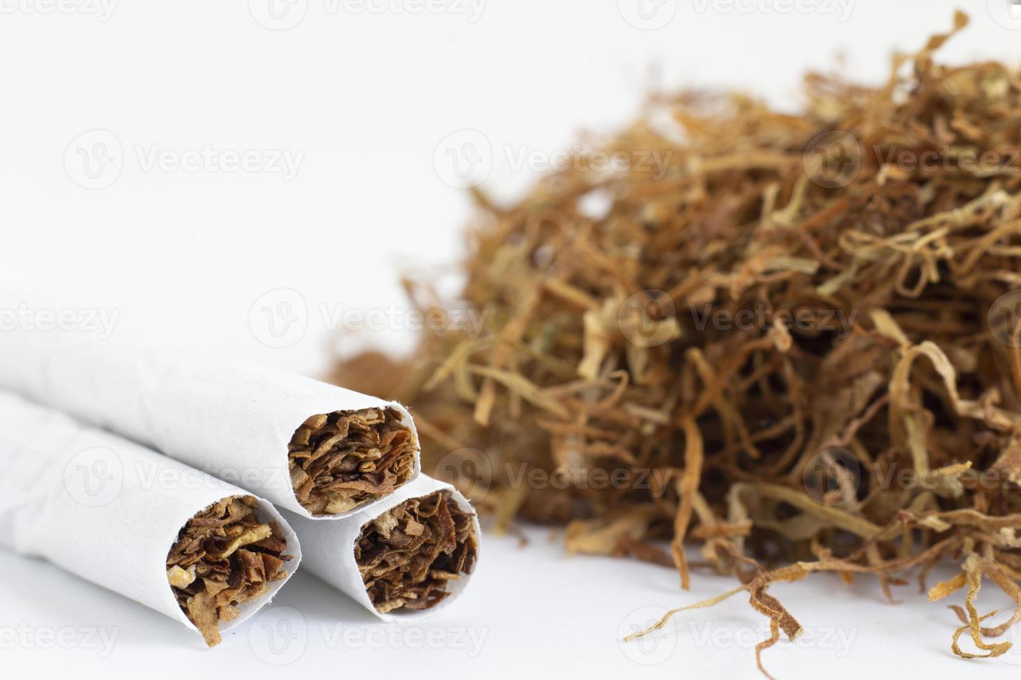 primer plano de cigarrillos sobre un fondo de tabaco seco. morir de cáncer debido al uso de tabaco y productos de tabaco. foto