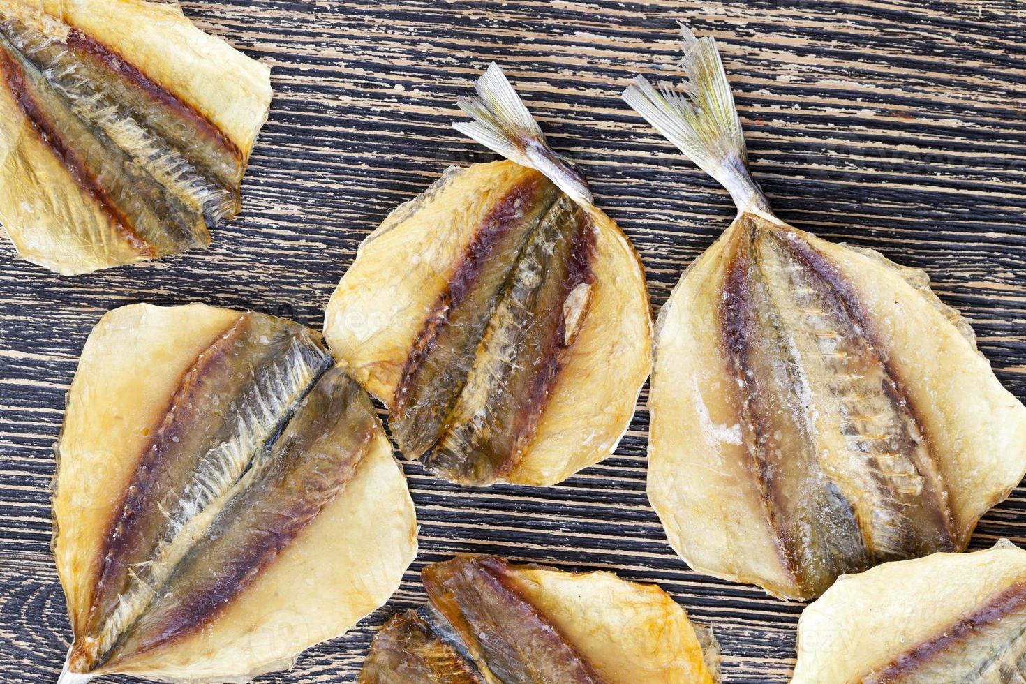 dried and butchered small fish on a wooden table photo