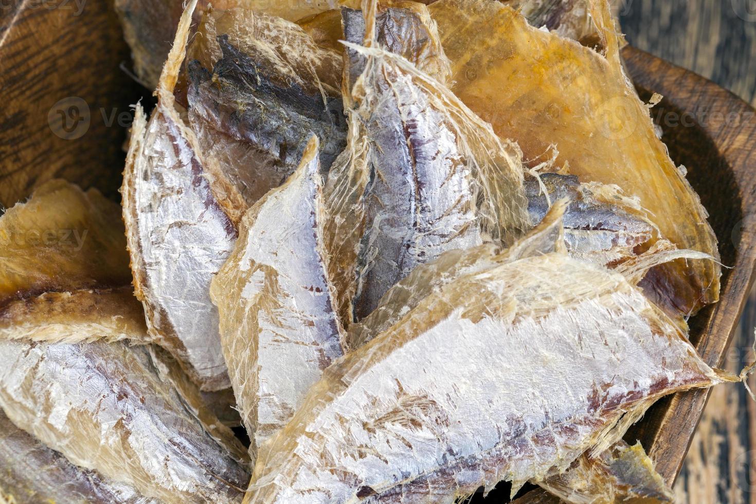 dried and butchered small fish on a wooden table photo