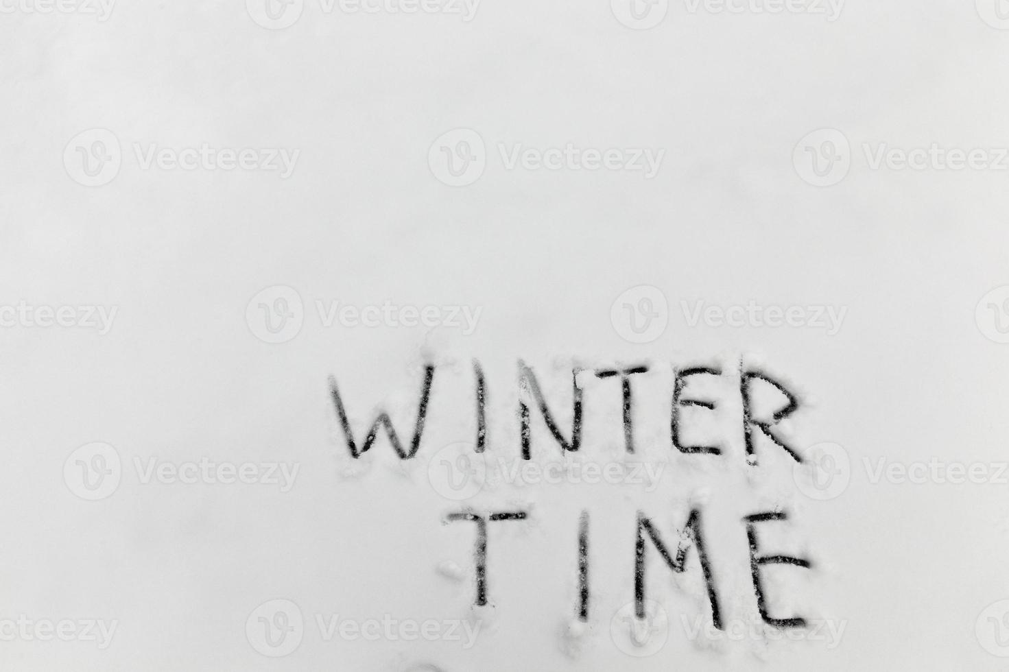 the words winter time drawn on the snow photo