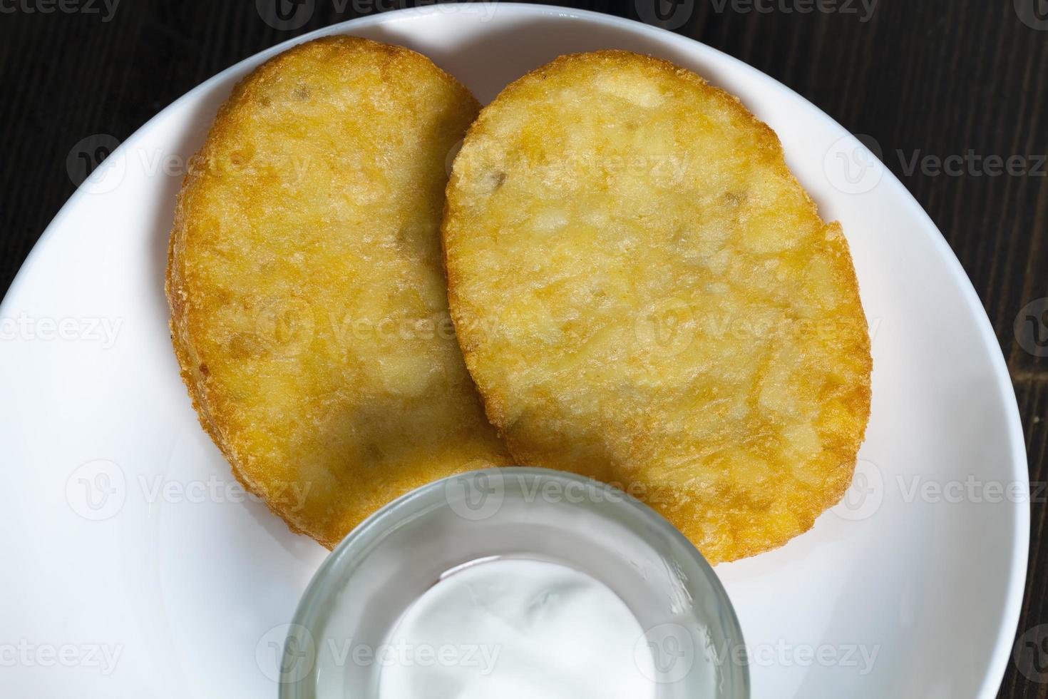 potato pancakes with sour cream on a plate photo
