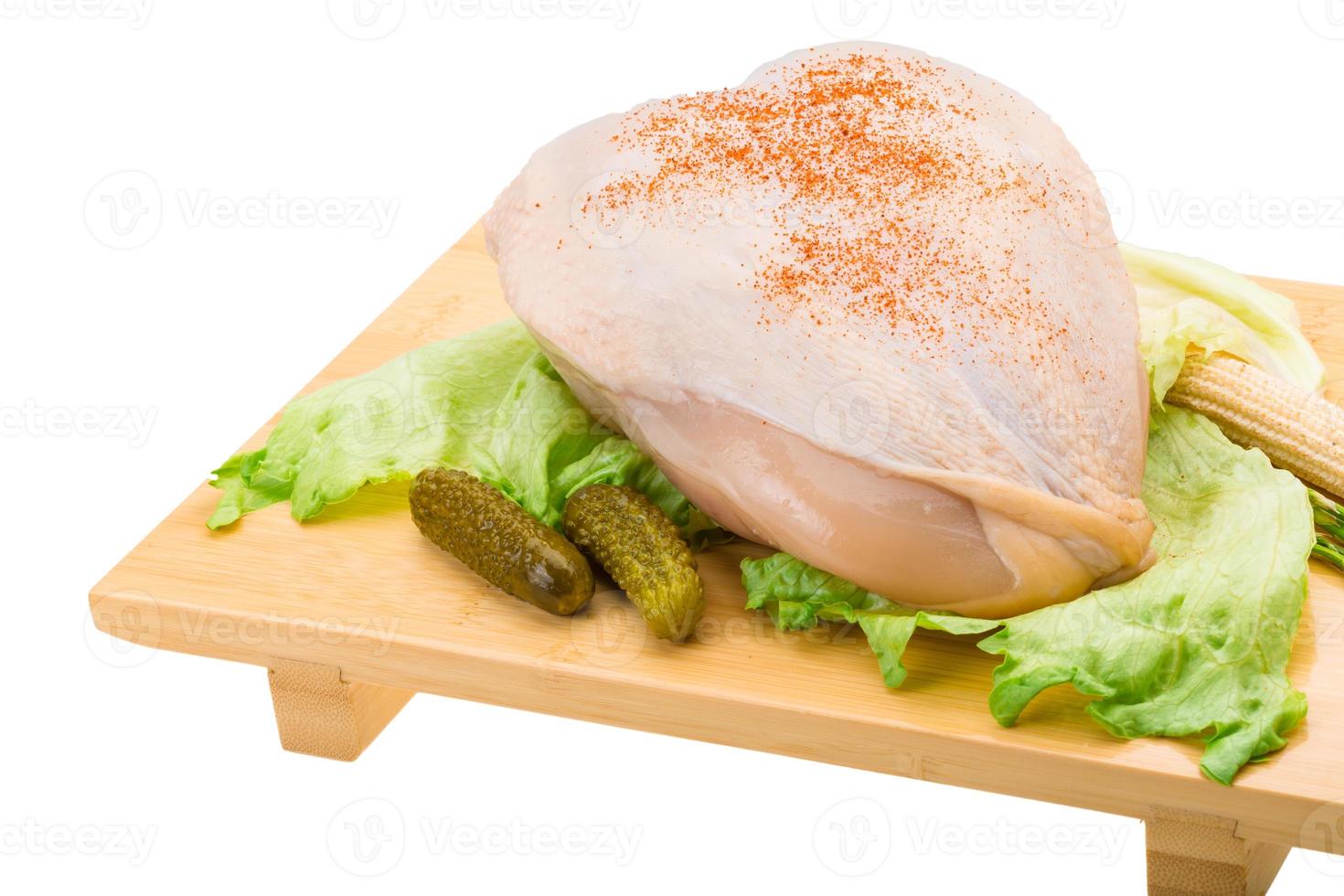 Chicken breast on wooden plate and white background photo