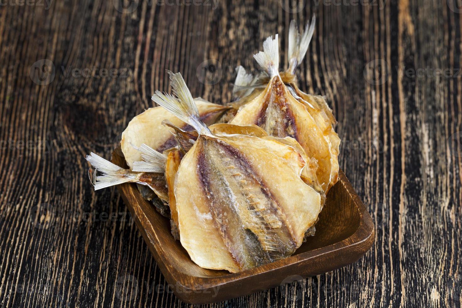 dried and butchered small fish on a wooden table photo