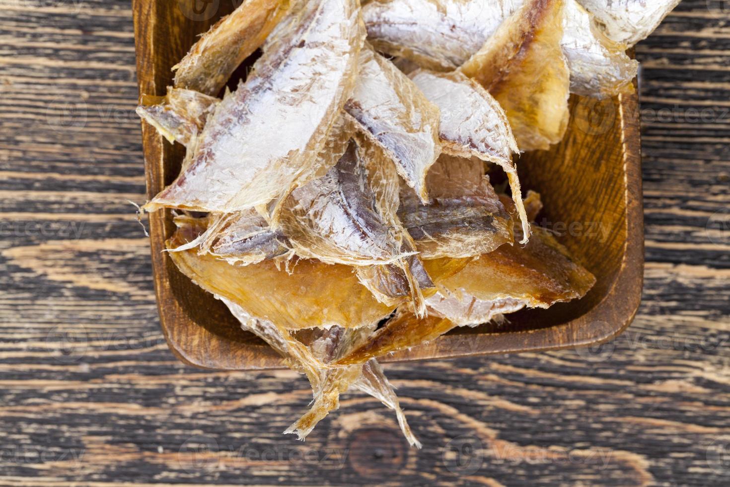 dried and butchered small fish on a wooden table photo