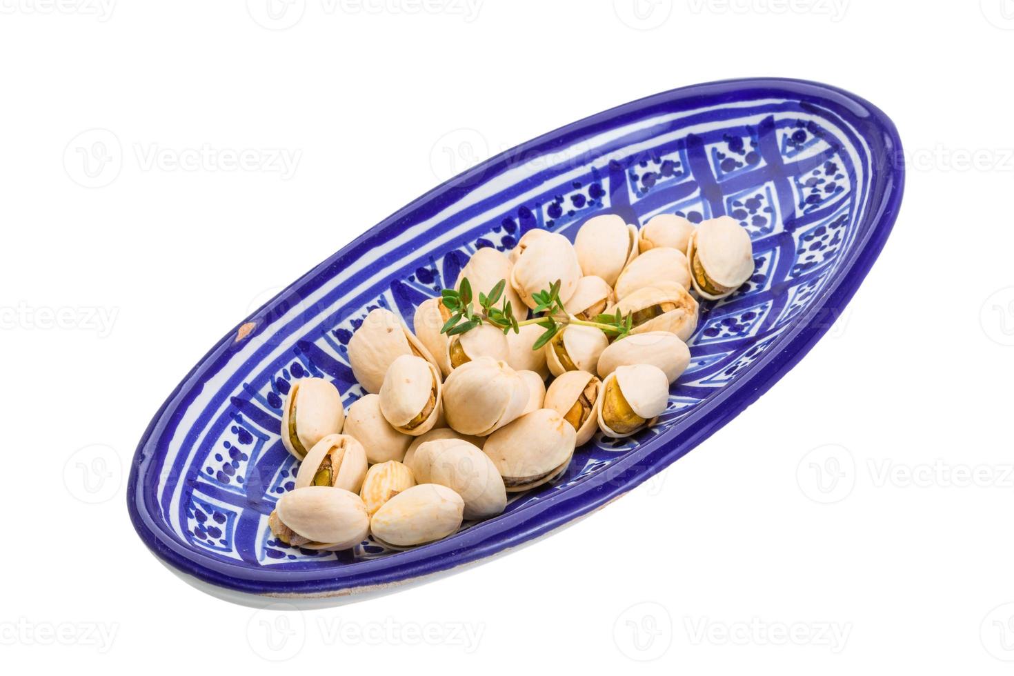 pistacho en un recipiente sobre fondo blanco foto