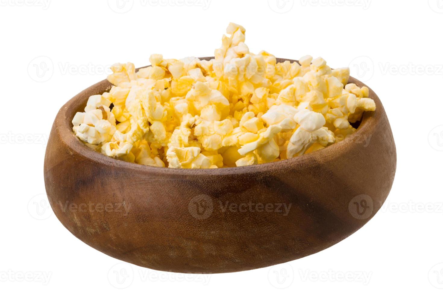 Palomitas de maíz en un recipiente sobre fondo blanco. foto