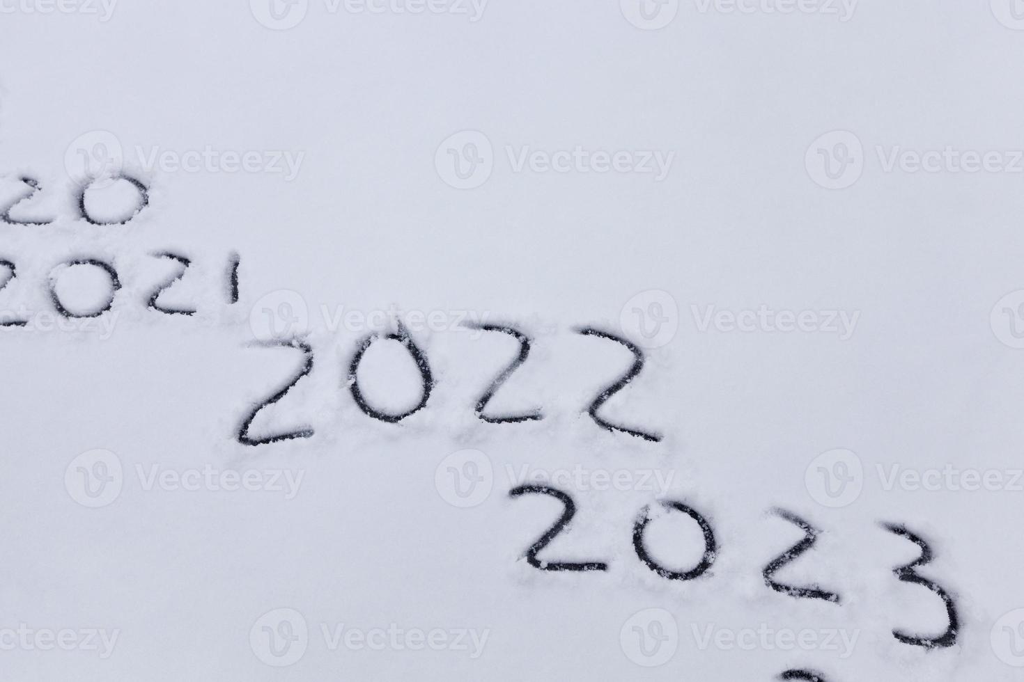 figures and the date of 2022 drawn on the snow photo