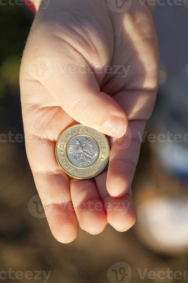 moneda en manos de un niño foto