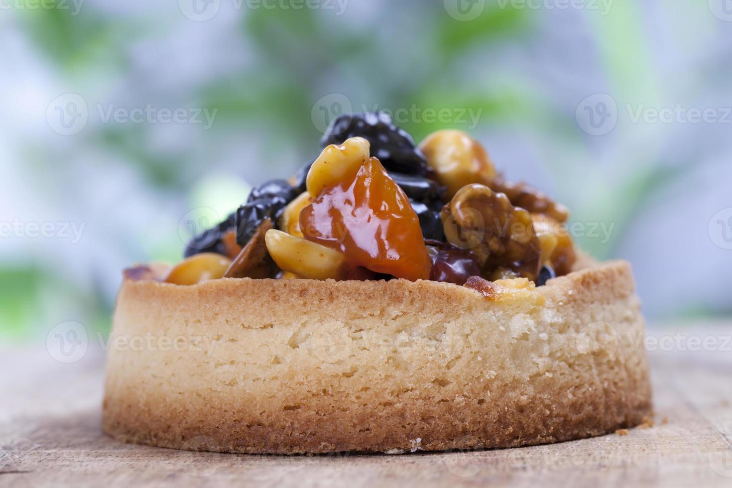 dough tartlet nuts and dried fruits covered with caramel photo