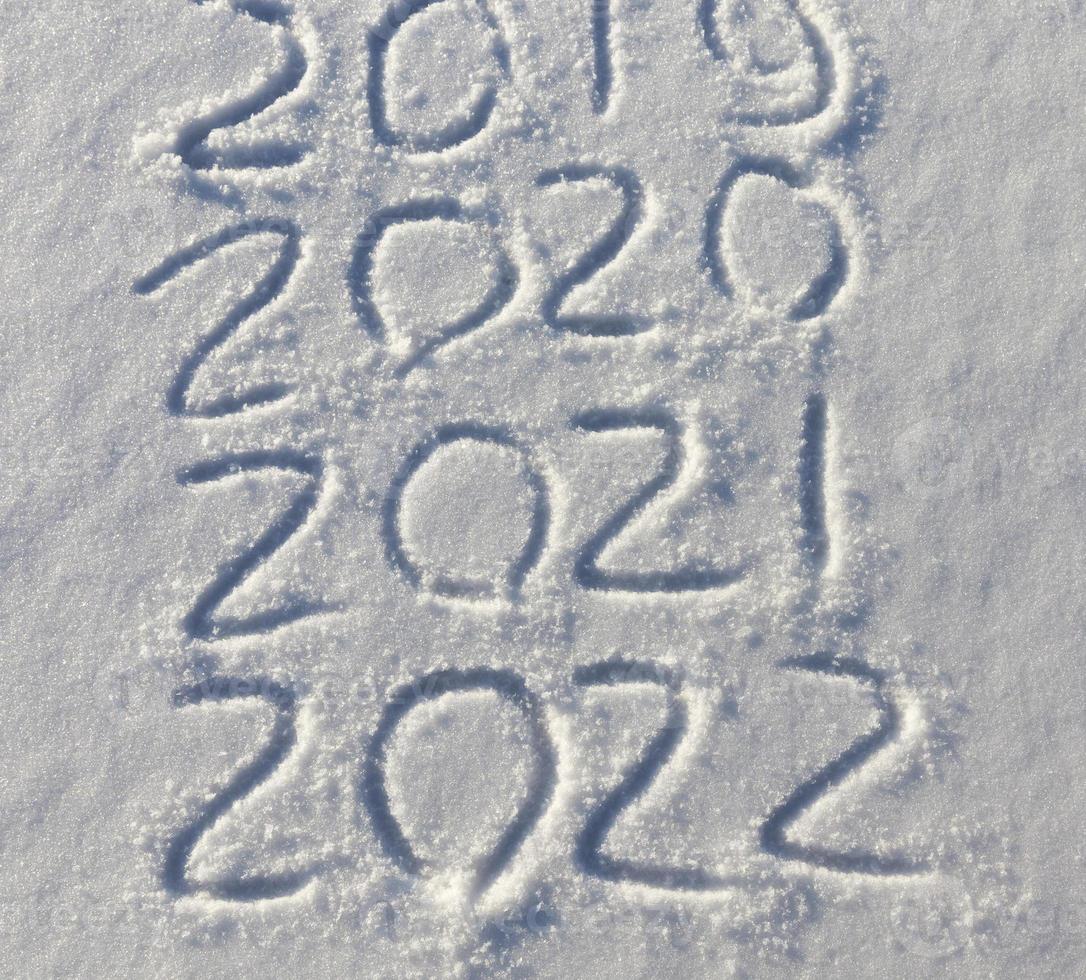 la inscripción sobre el nuevo año 2022 en la nieve en invierno foto