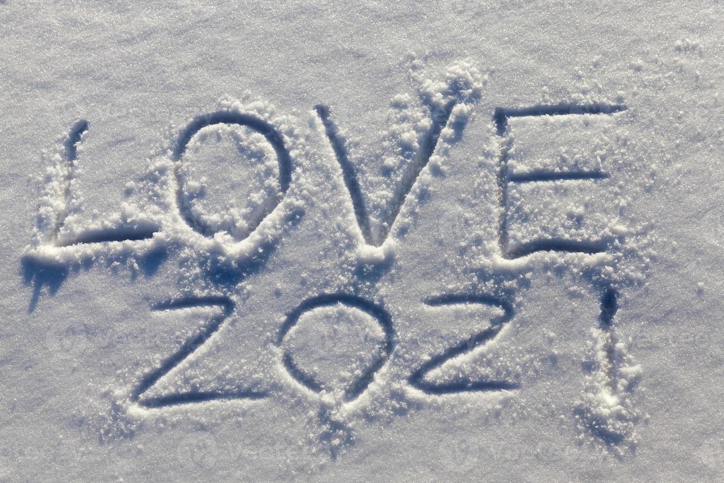 the words love 2021 drawn on the snow photo