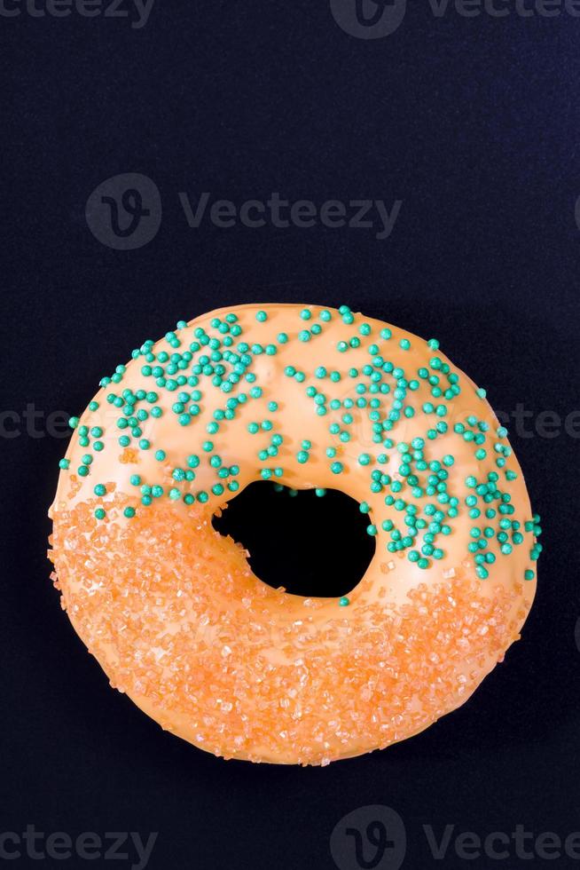 fresh doughnut covered with orange chocolate with mango flavor photo