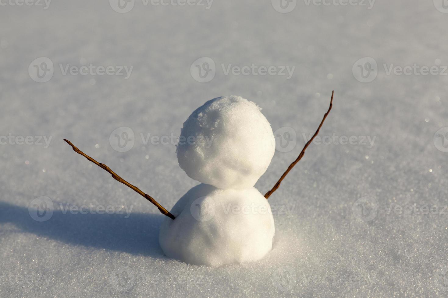 un pequeño muñeco de nieve en la temporada de invierno, de cerca foto